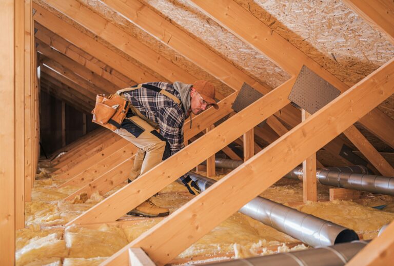 ouvrier en train d'effectuer une isolation par insufflation des combles