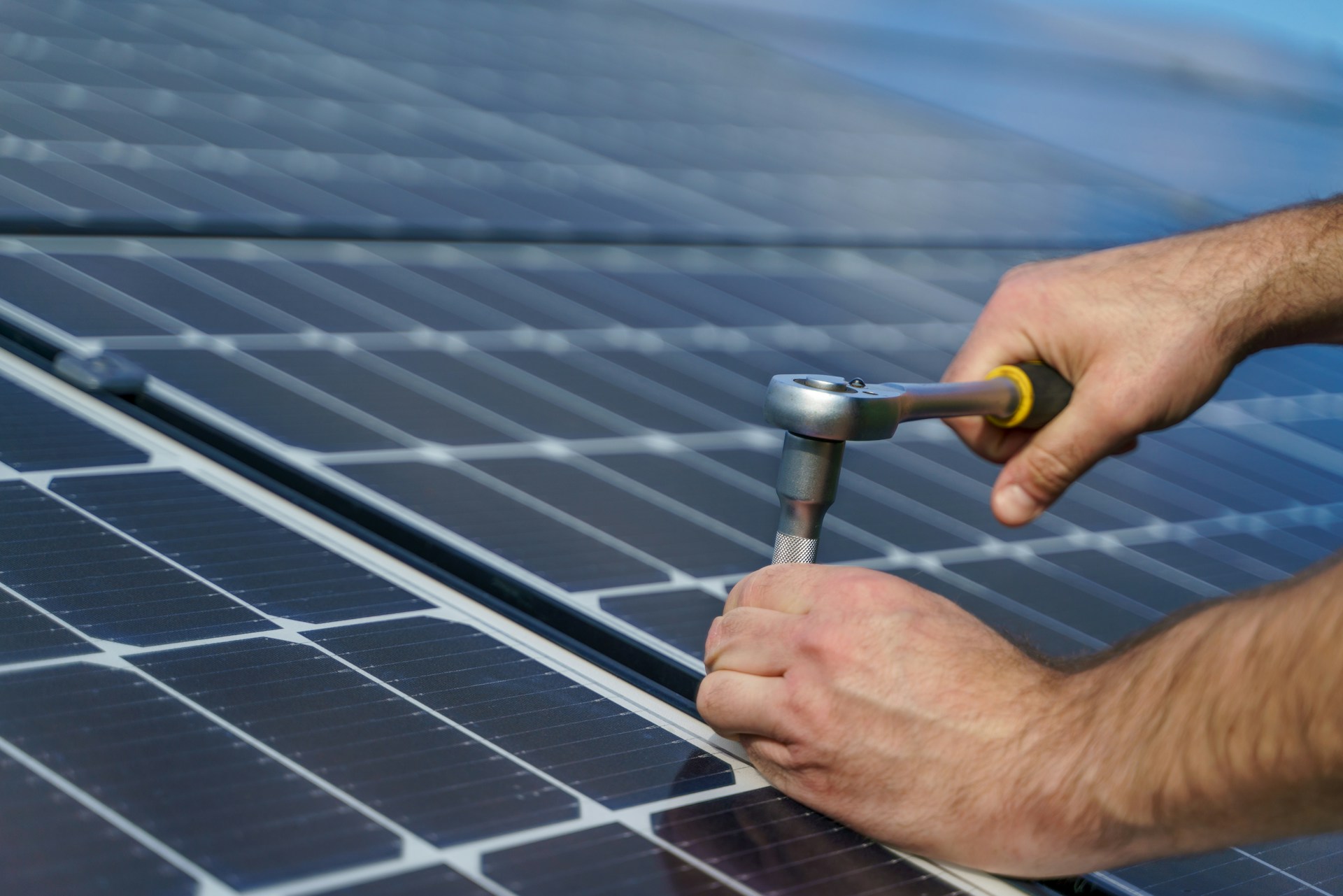 artisan en train de réaliser l'entretien de panneaux solaires