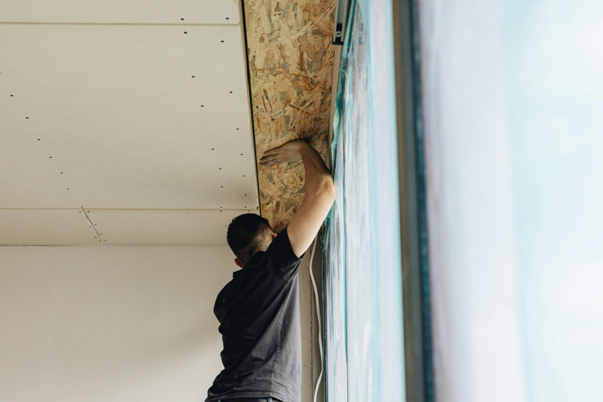 artisan en train de réaliser l'isolation d'un plafond déjà existant