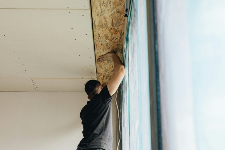 artisan en train de réaliser l'isolation d'un plafond déjà existant