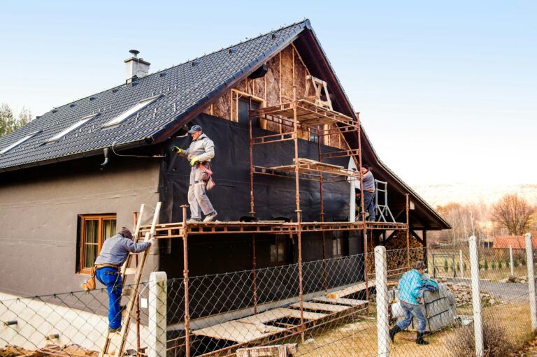 artisans en train de poser le doublage extérieur des murs d'une maison