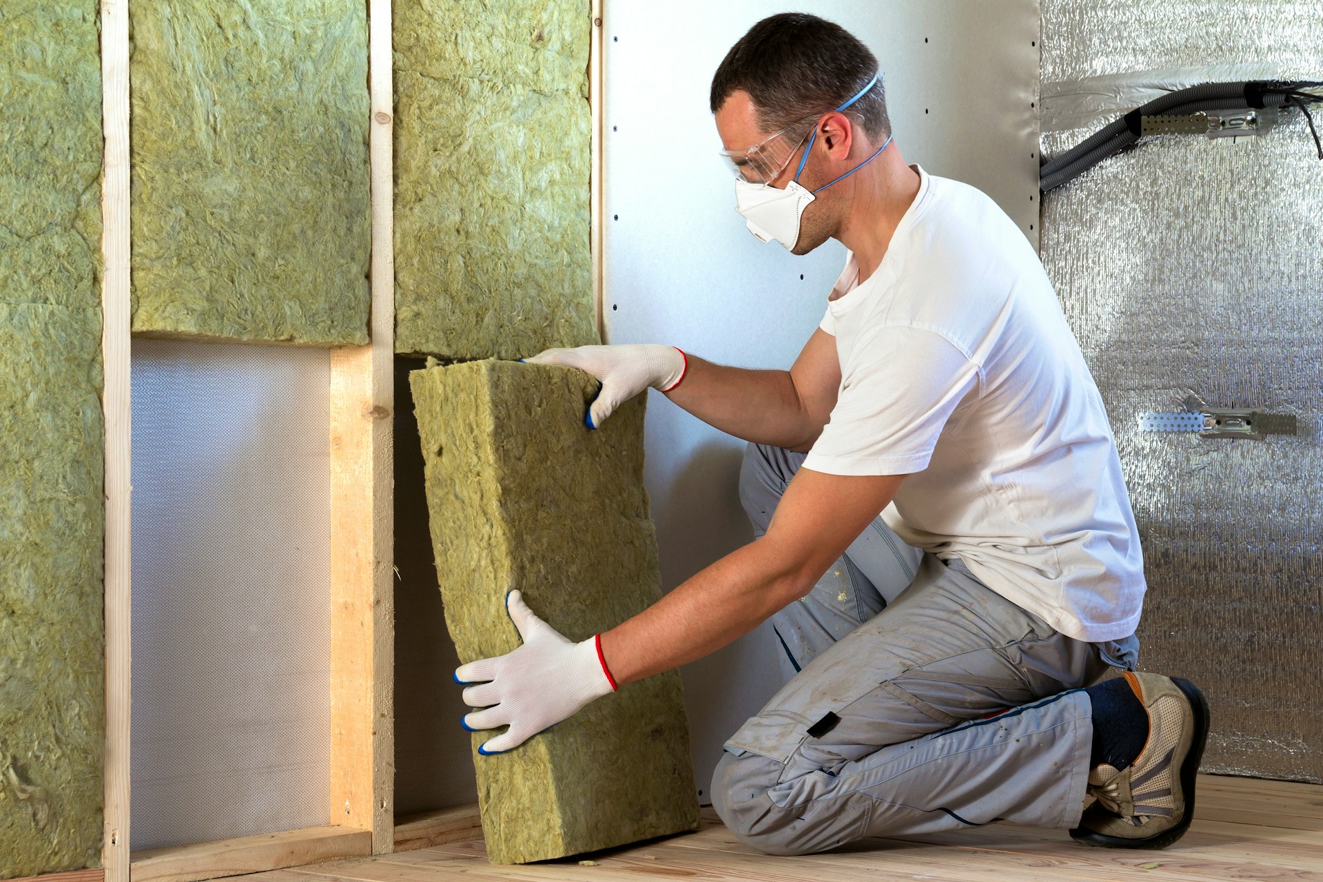 artisan en train de réaliser l'isolation d'un mur creux