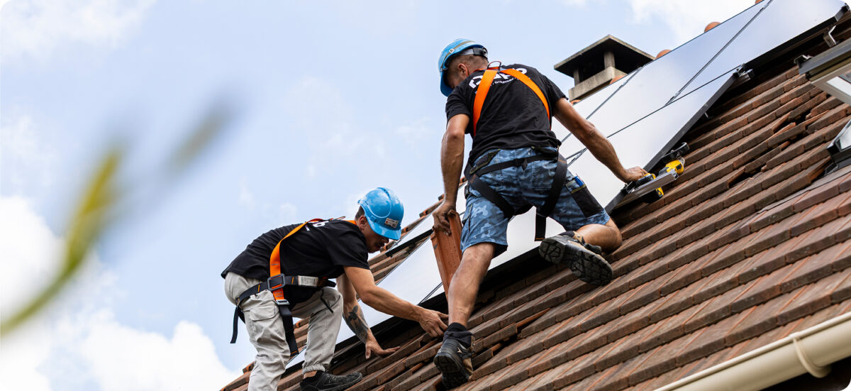 artisans en train d'installer des panneaux solaires photovoltaïques